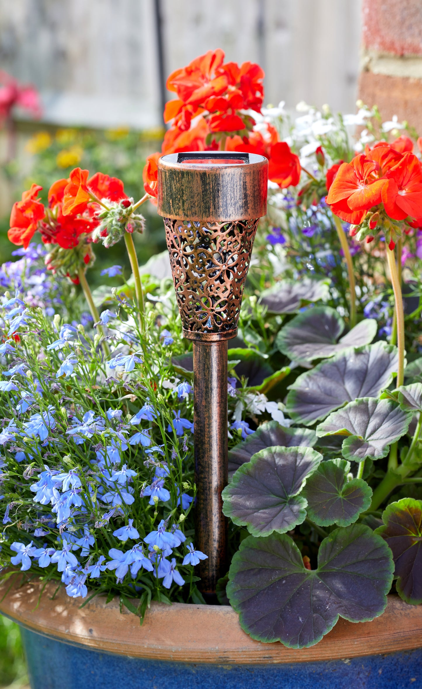 Decorative solar lamp in a garden with flowers and plants