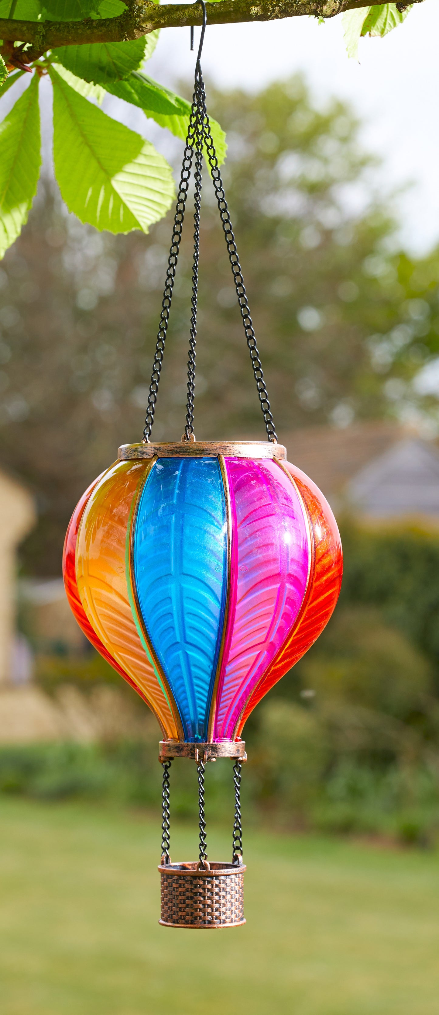 Colorful hot air balloon-shaped hanging decoration in a garden setting