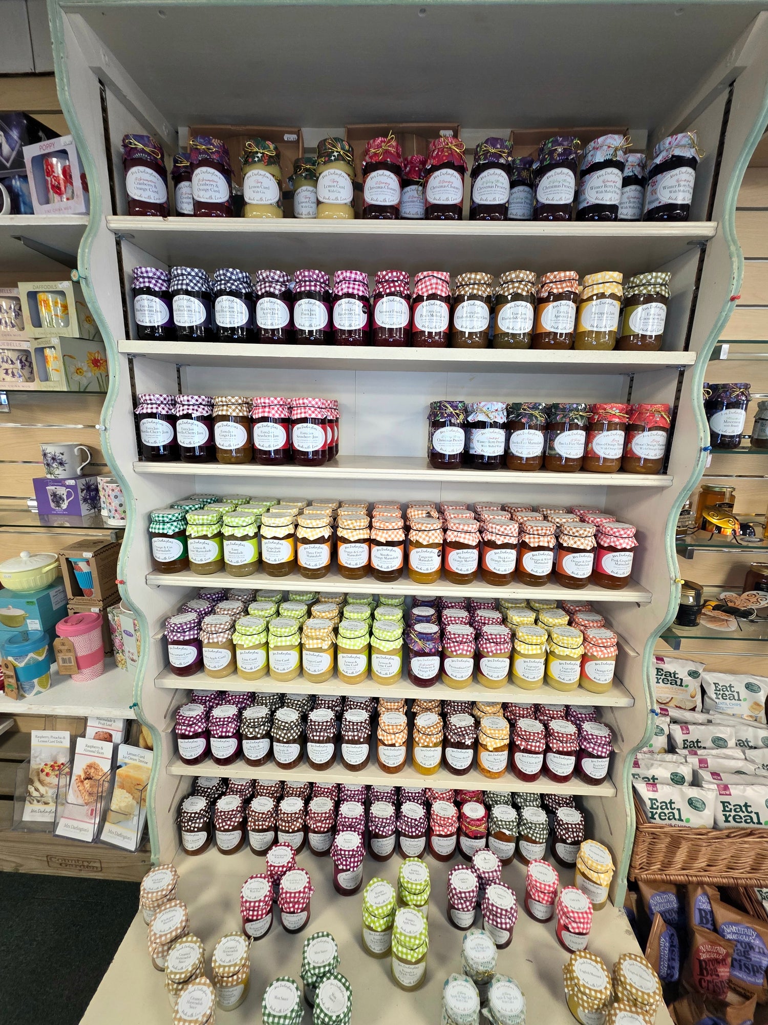 Shelf displaying a variety of jars with labels in a store setting
