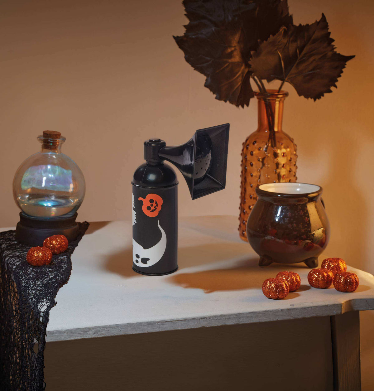 A novelty black can-shaped speaker with a vintage gramophone horn attached, featuring a white ghost and orange skull graphic on the side, set against a plain white background.