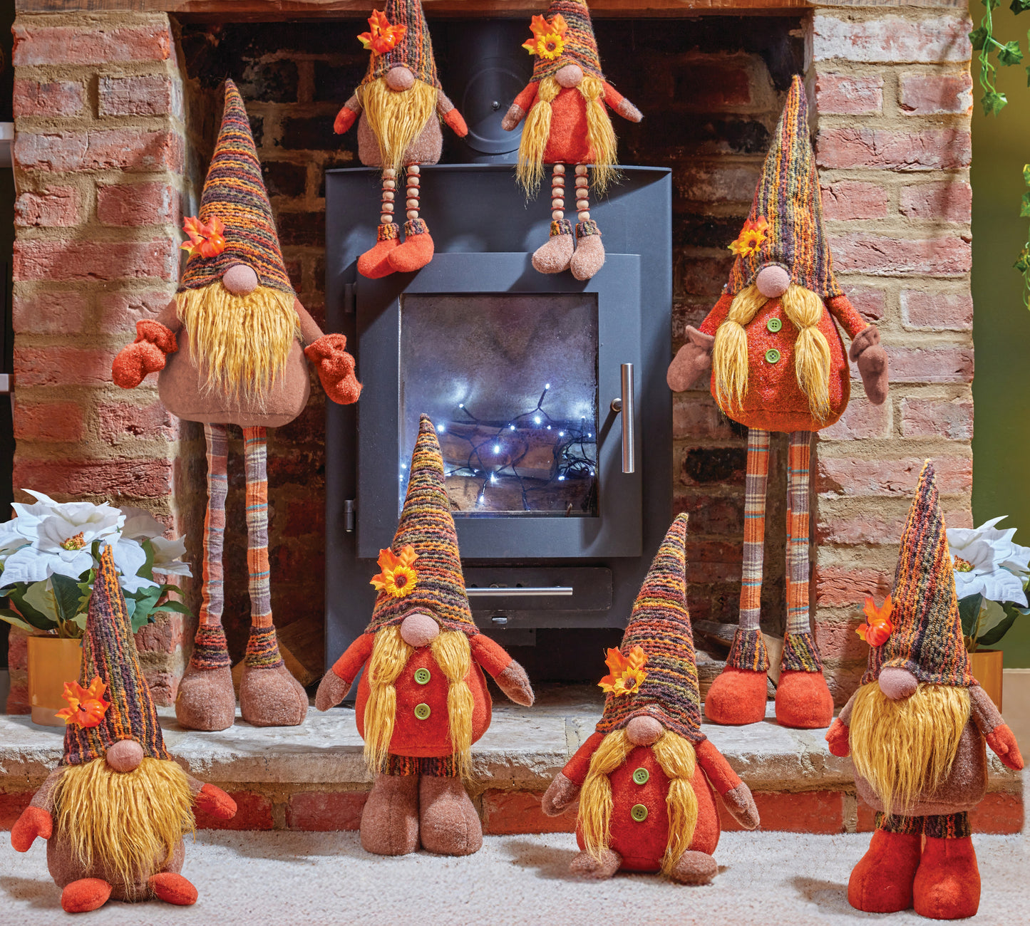 Decorative gnomes in front of a fireplace with a warm glow.