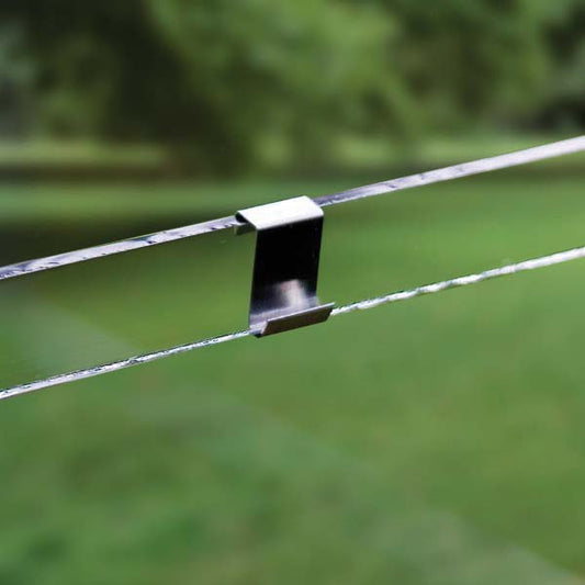 Metal clip on a wire with a blurred green background