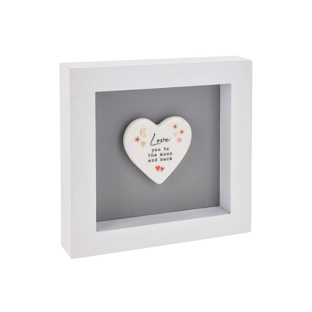 Heart-shaped ceramic plaque with 'Love you to the moon and back' text in a white frame on a white background