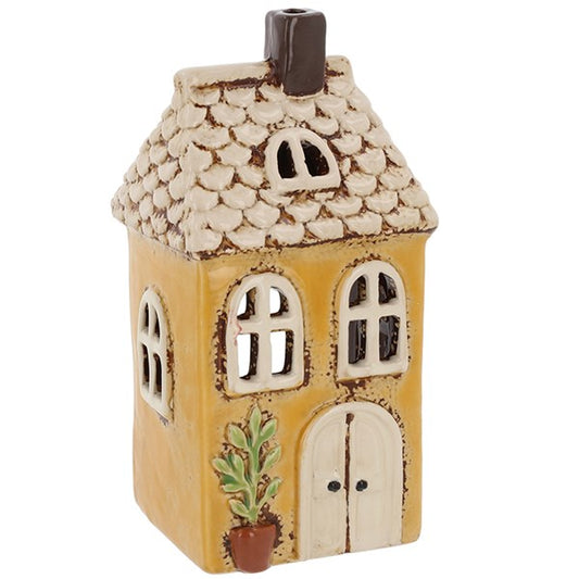Ceramic house-shaped lantern with textured roof and decorative elements on a white background