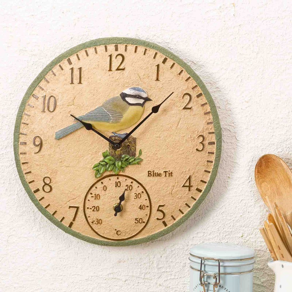 Decorative wall clock with a bird design on a white wall.