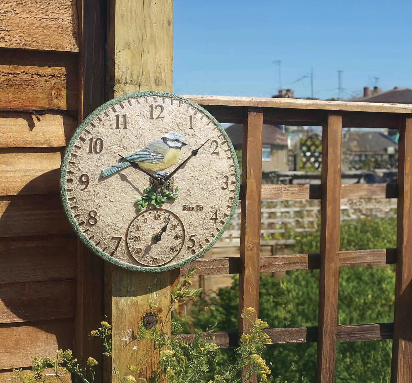 Decorative clock with a bird design on a wooden post outdoors