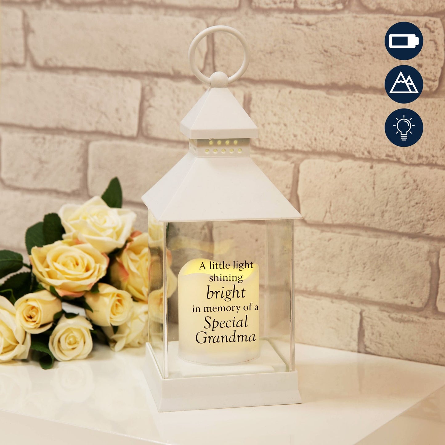 Lantern with a message about a special grandma next to yellow roses on a brick wall background