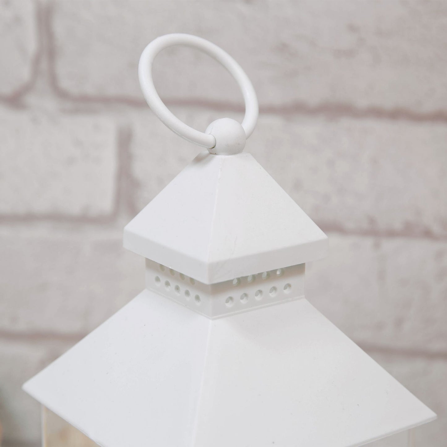White lantern with a handle on a neutral background