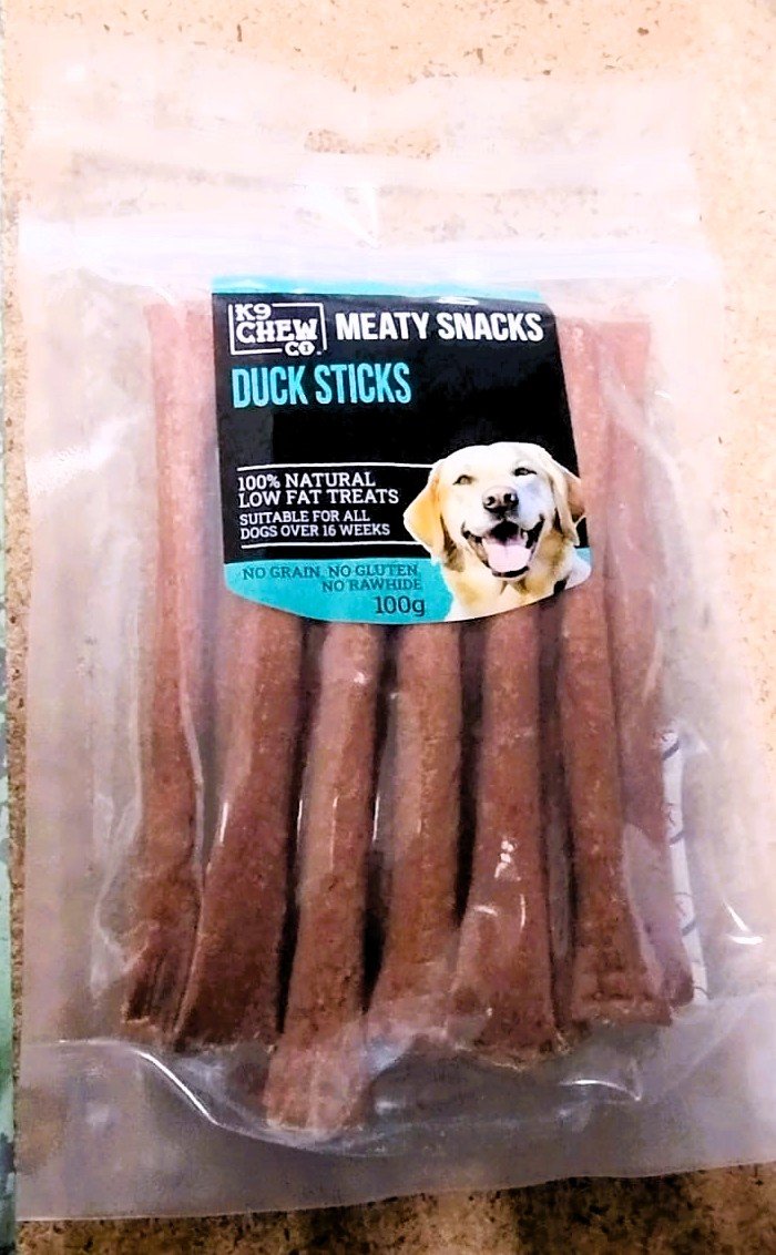 Package of K9 Crew Duck Sticks dog treats on a wooden surface