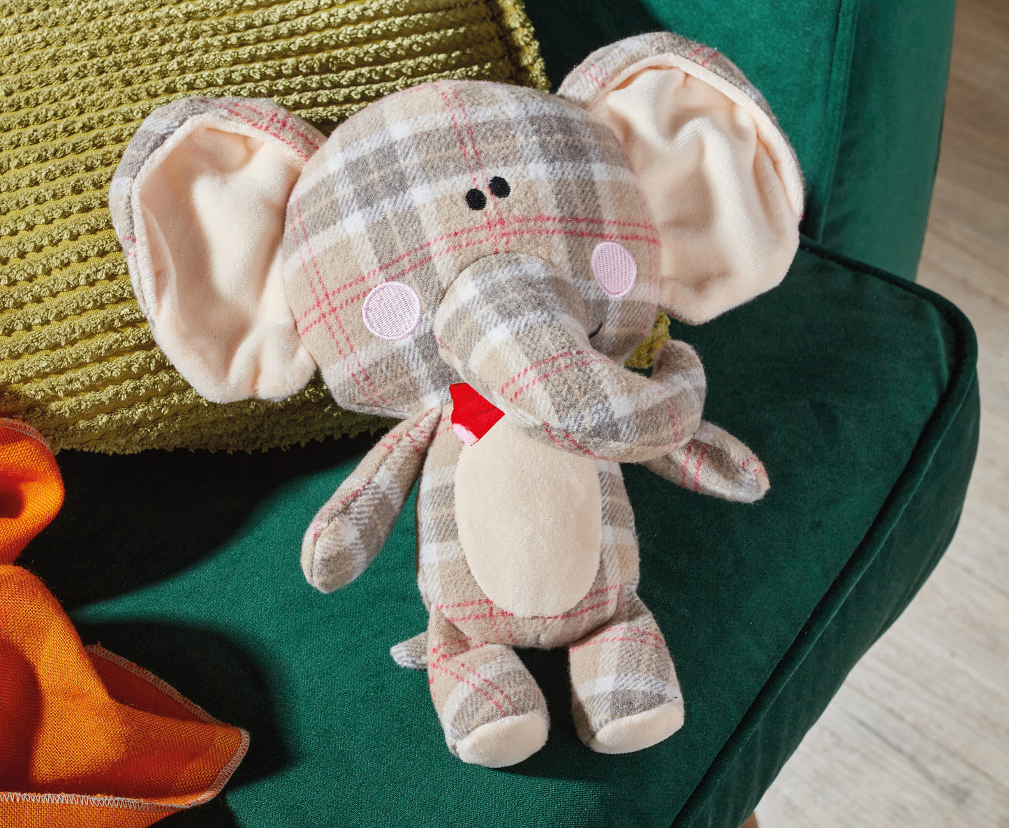 Plush elephant toy with checkered pattern on a green surface