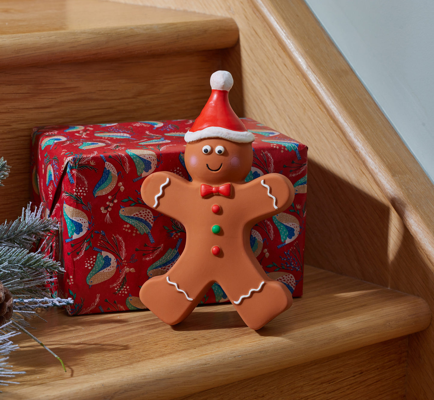 Gingerbread man decoration with a Santa hat on a wooden staircase
