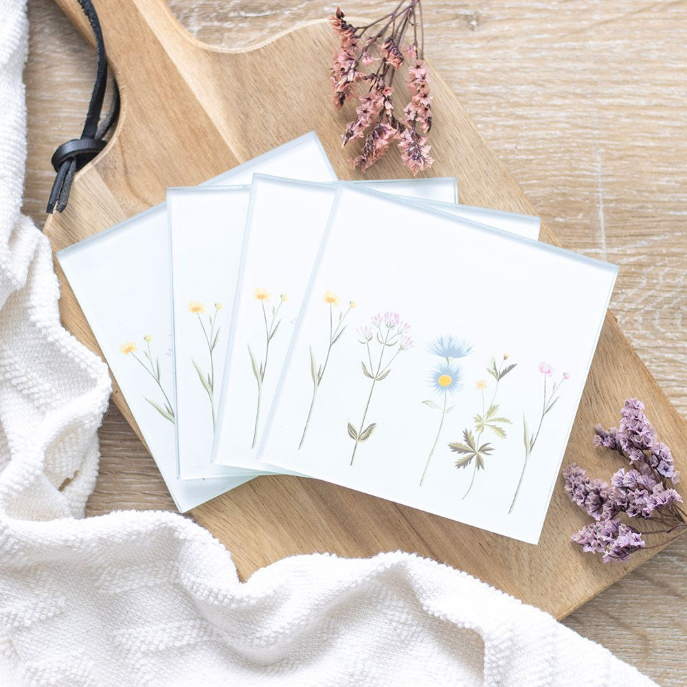 Set of greeting cards with floral designs on a wooden surface with dried flowers.