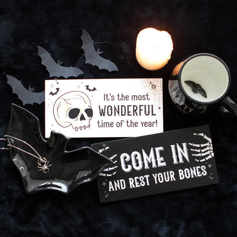 Halloween-themed decorations with signs and a candle on a dark background