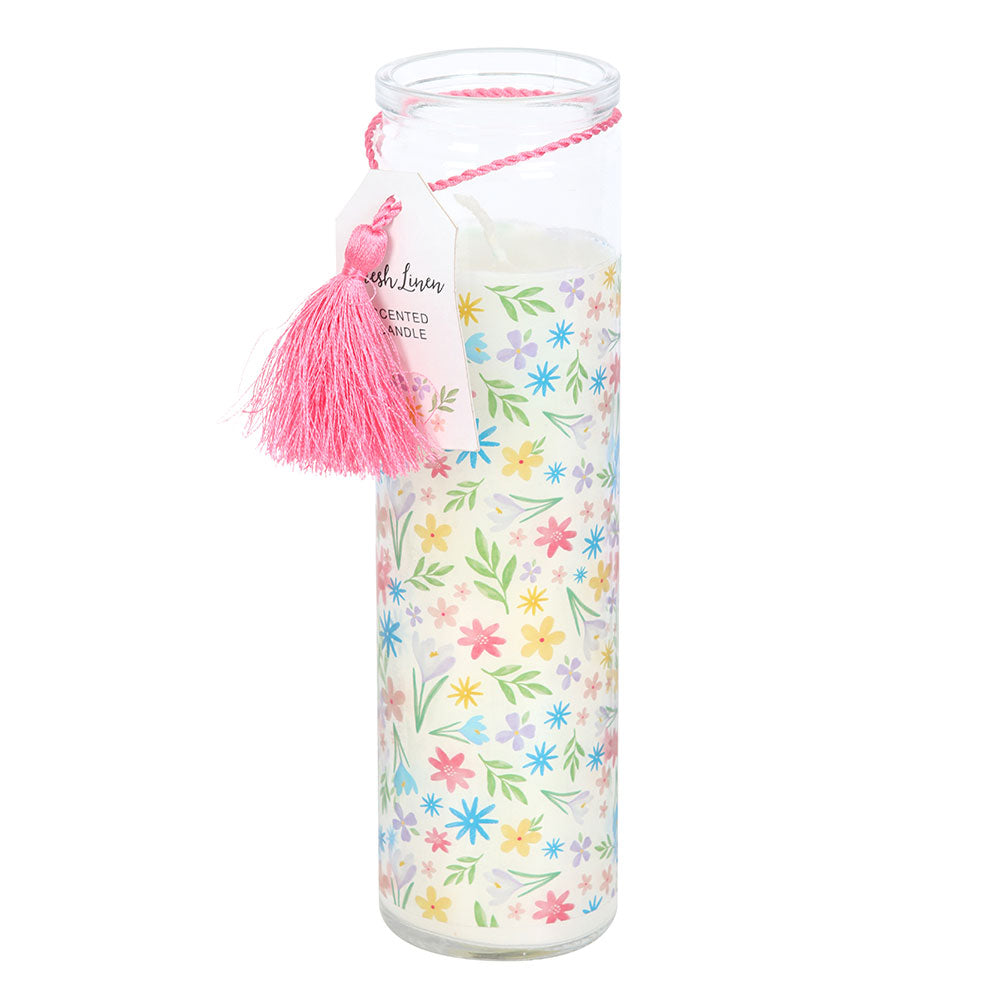 Decorative candle with floral pattern and pink tassel on a white background