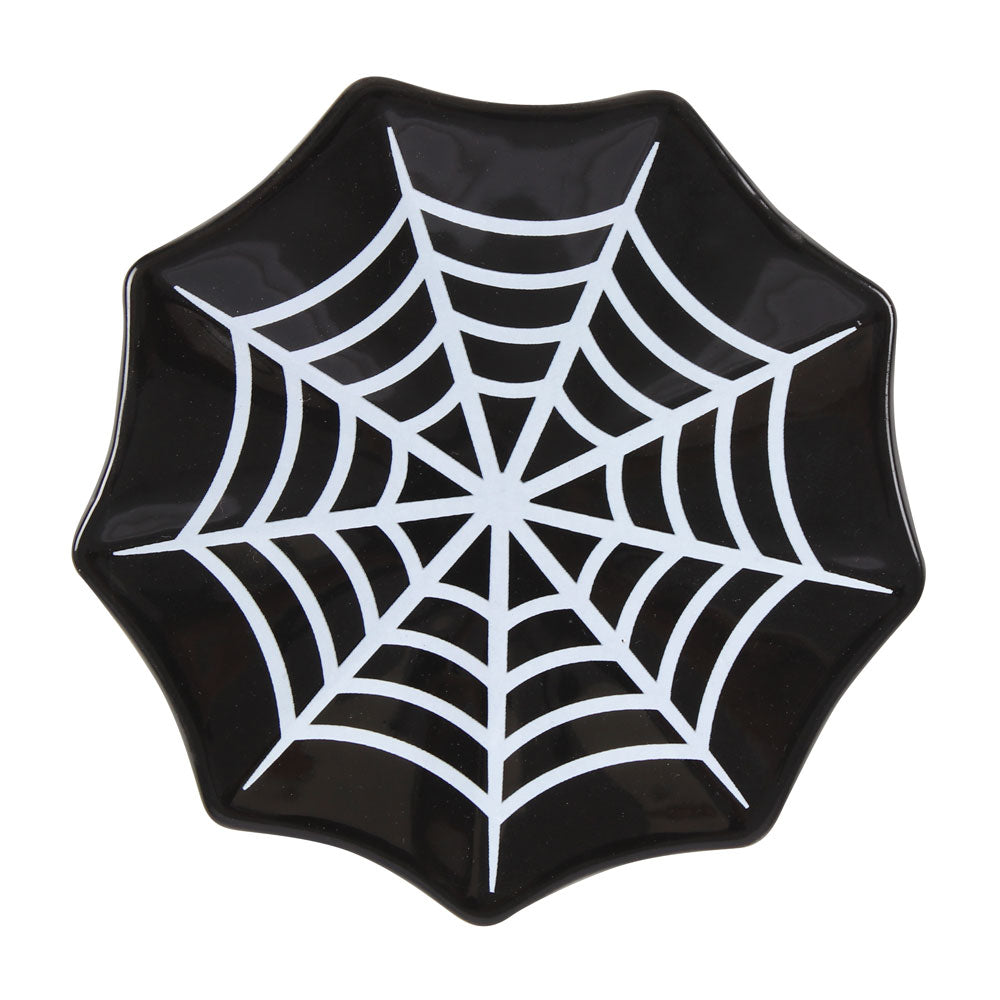 Black plate with a white spider web design on a white background
