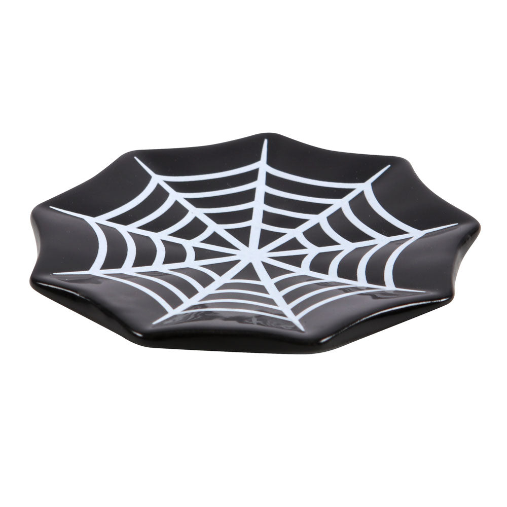 Black plate with spider web design on a white background