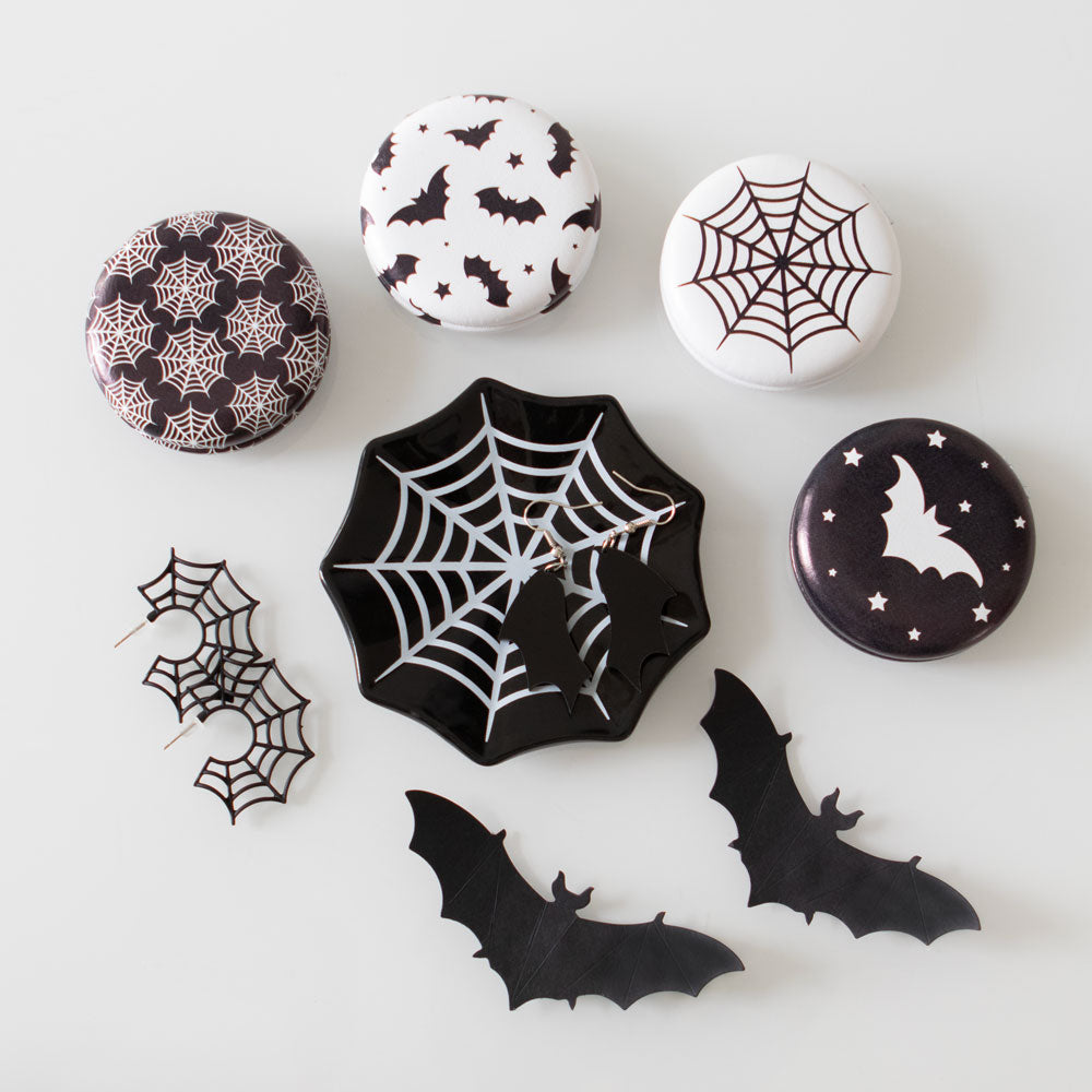 Halloween-themed decorative items including spider webs, bats, and stars on a white background.