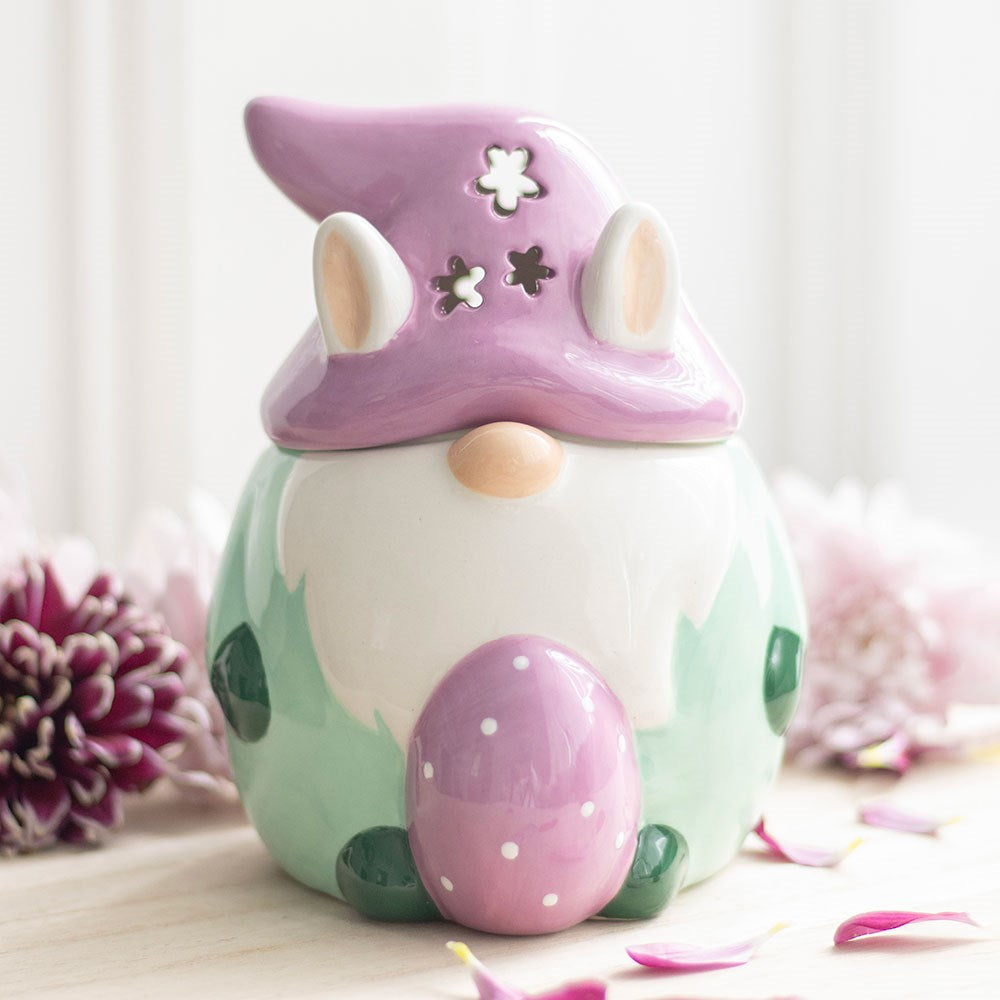 Decorative gnome with a purple hat and pink egg on a light background