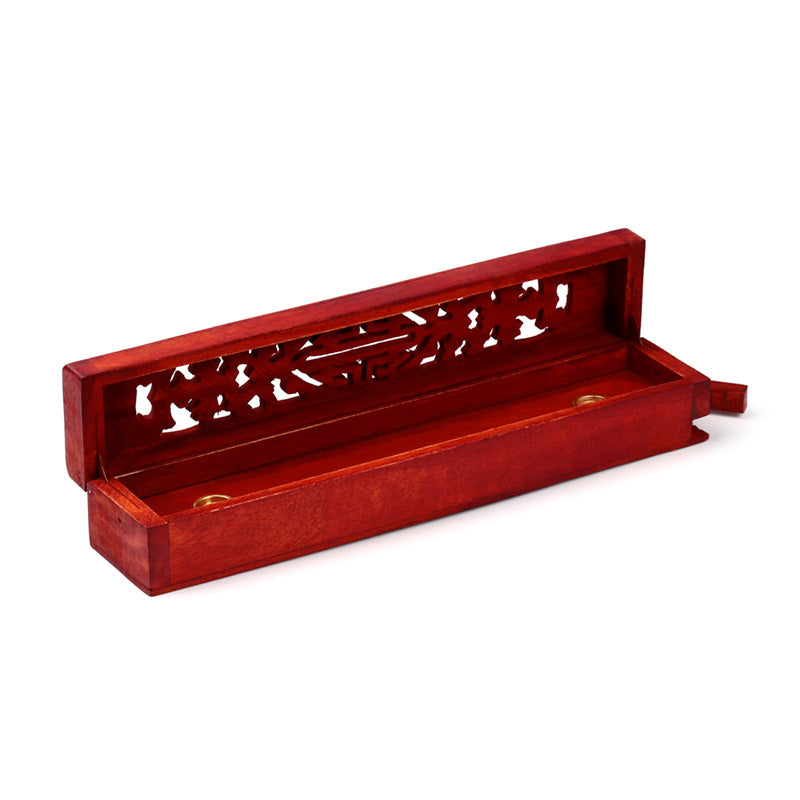 Red wooden incense holder with intricate carvings on a white background