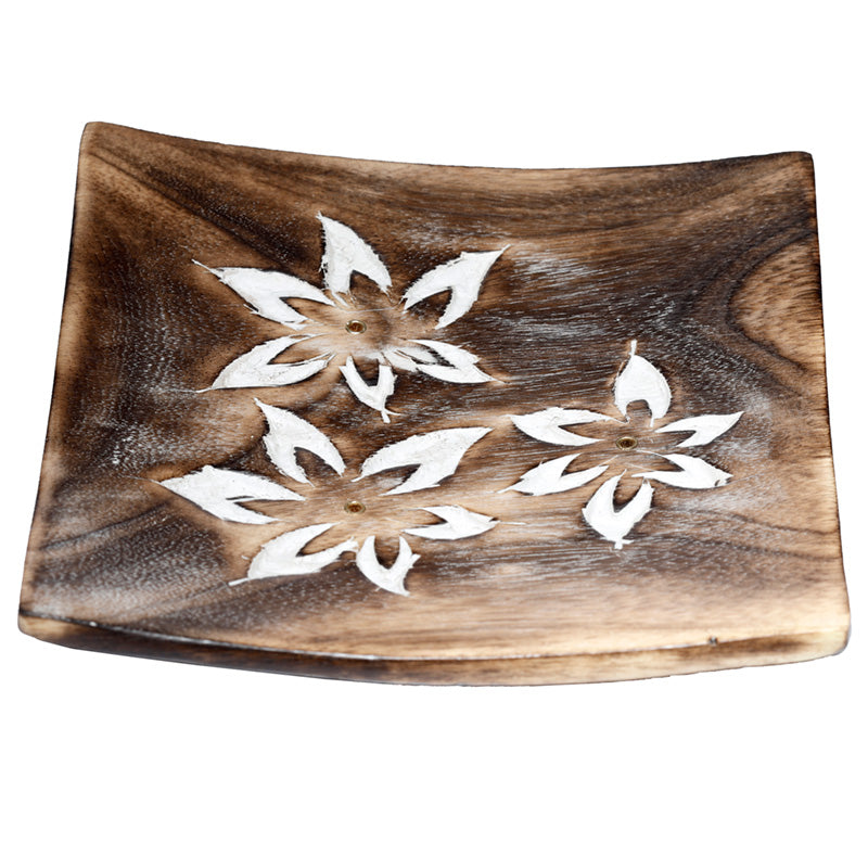 Wooden tray with white floral cutouts on a white background