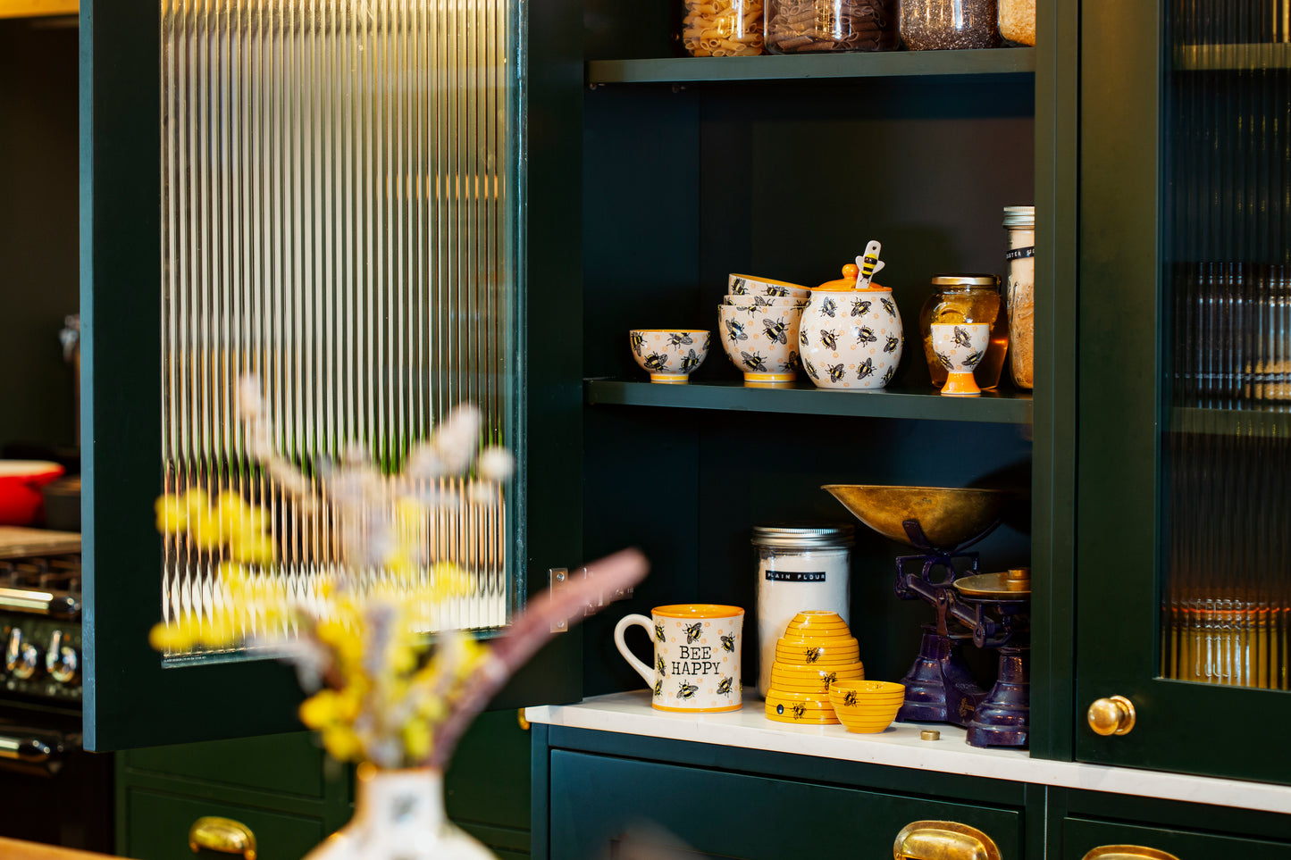 Bee themed honey jar in a cupboard with other bee themed items
