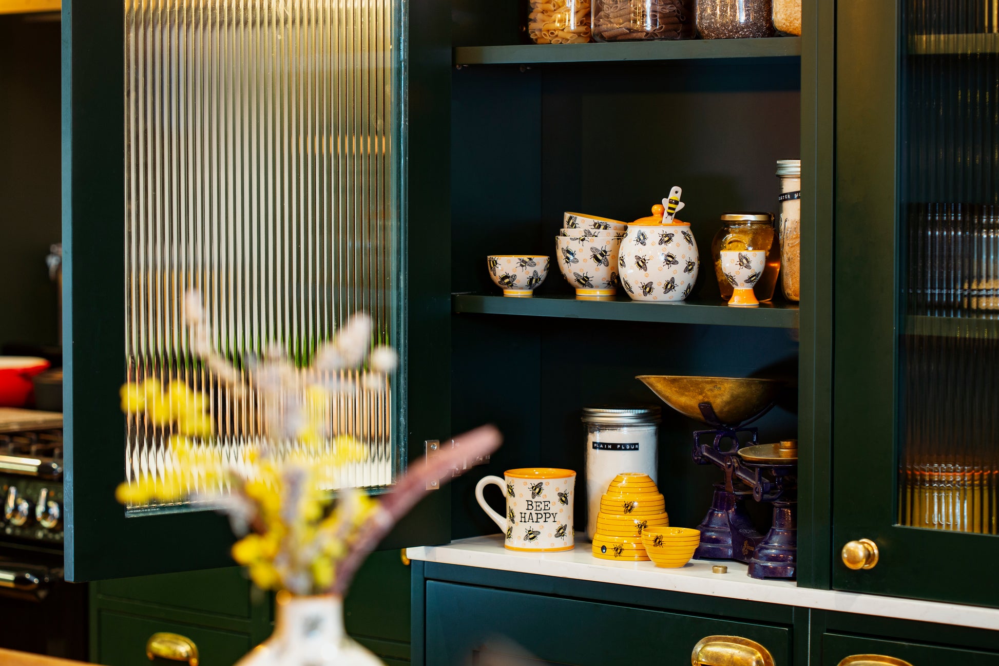 Bee themed honey jar in a cupboard with other bee themed items