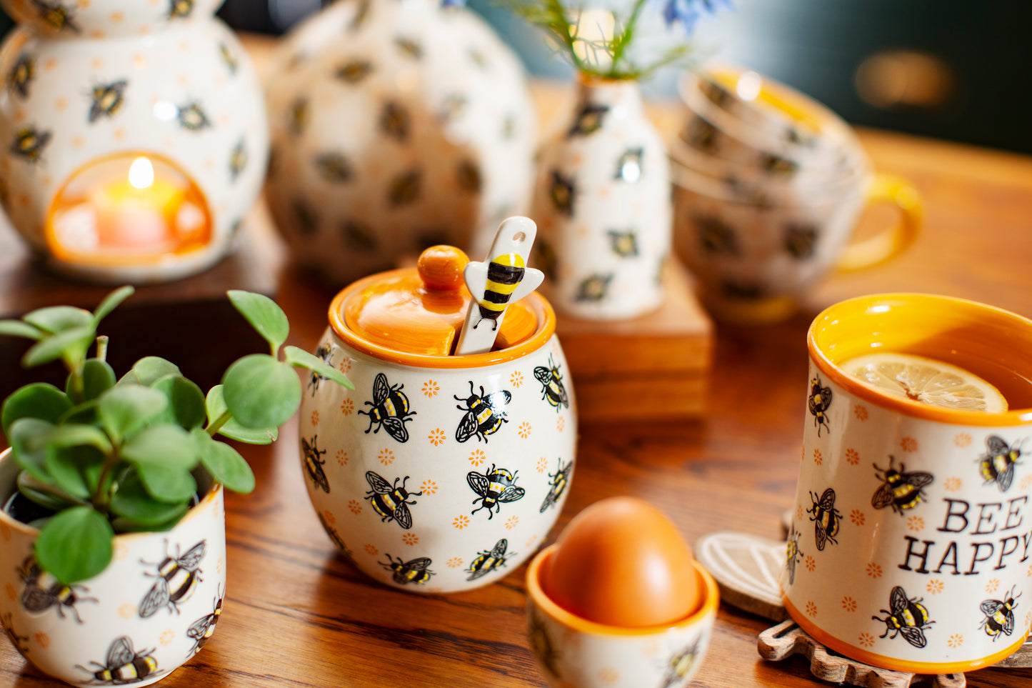 Bee themed honey jar on a table with other bee themed items