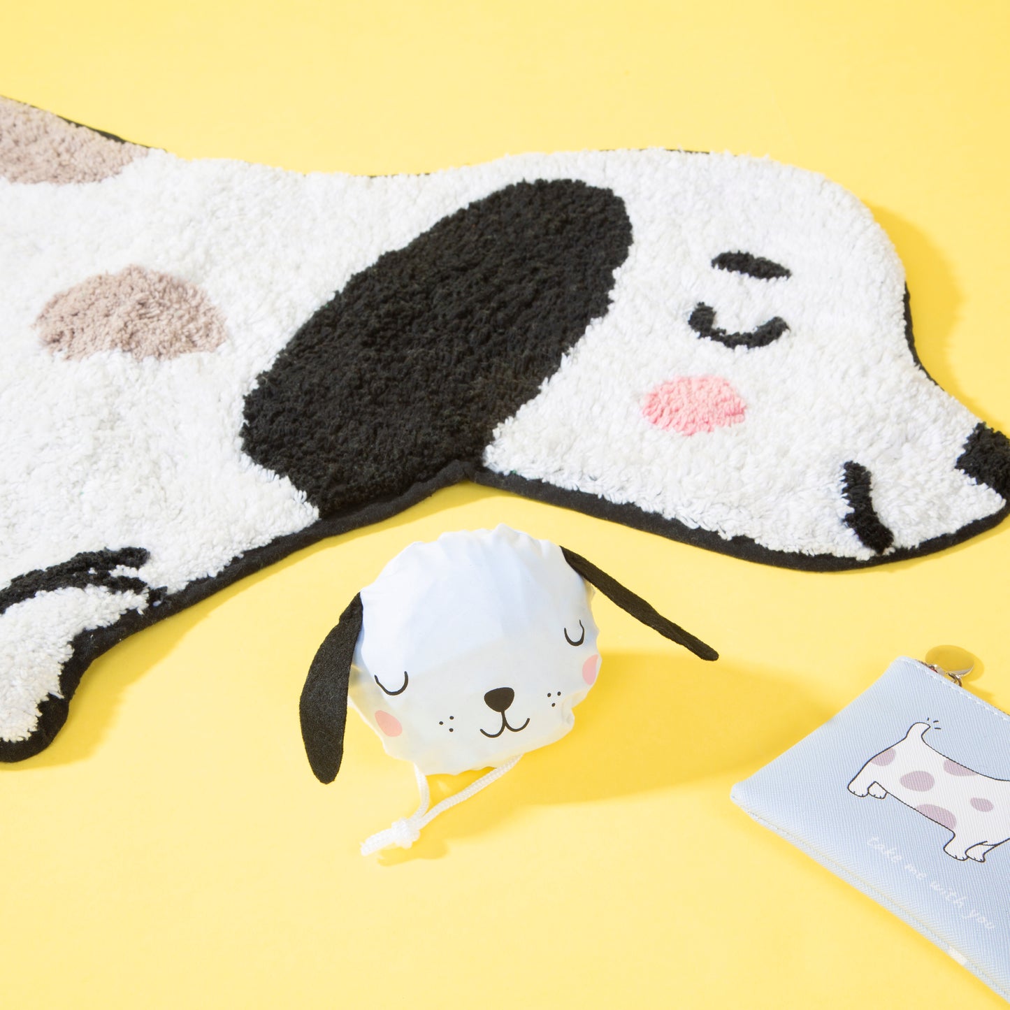 Cute dog-themed rug, plush toy, and card on a yellow background
