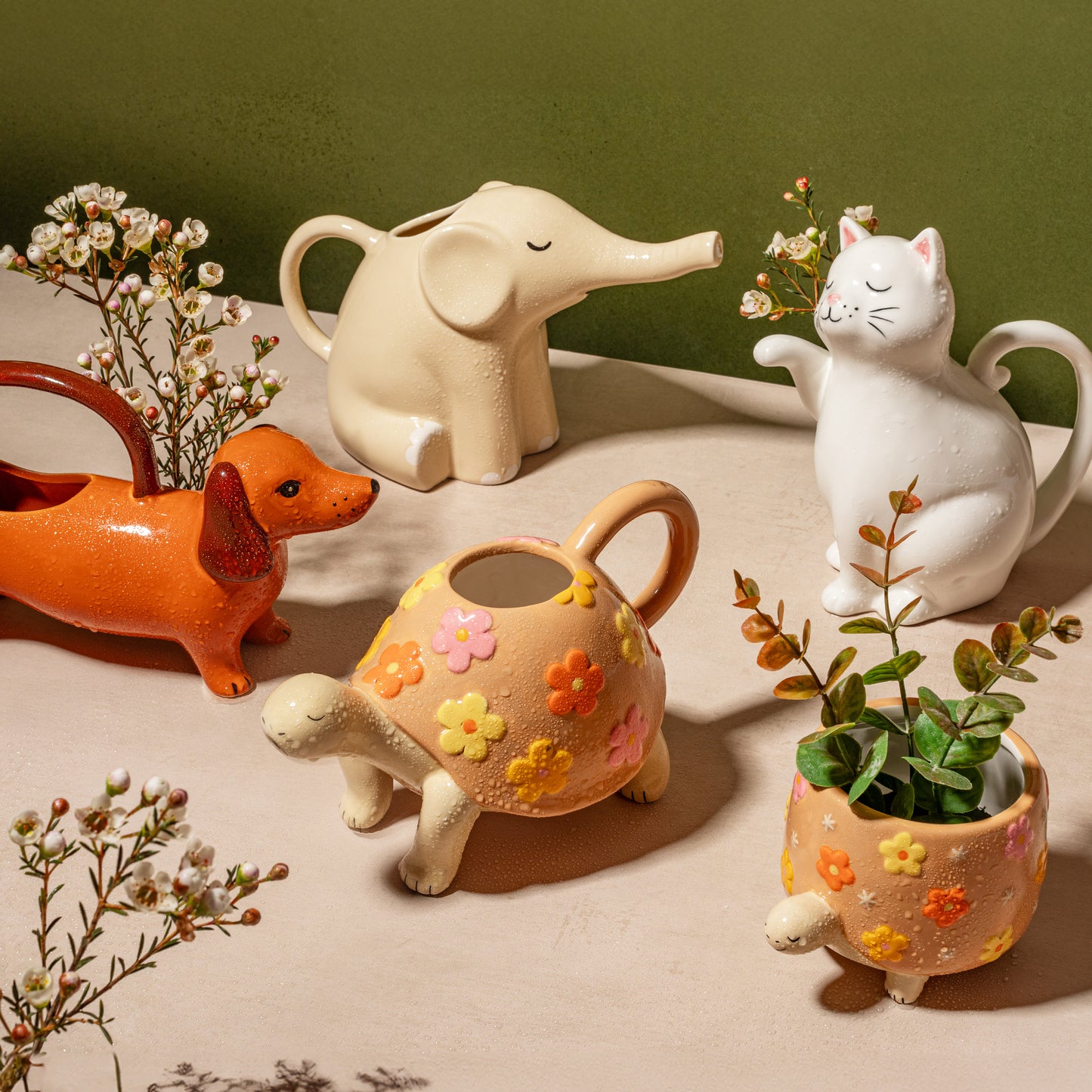 Set of ceramic animal planters including a dog, elephant, cat, and turtle on a neutral background.