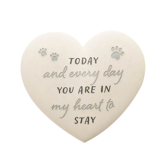 Heart-shaped stone with engraved text and paw prints on a white background