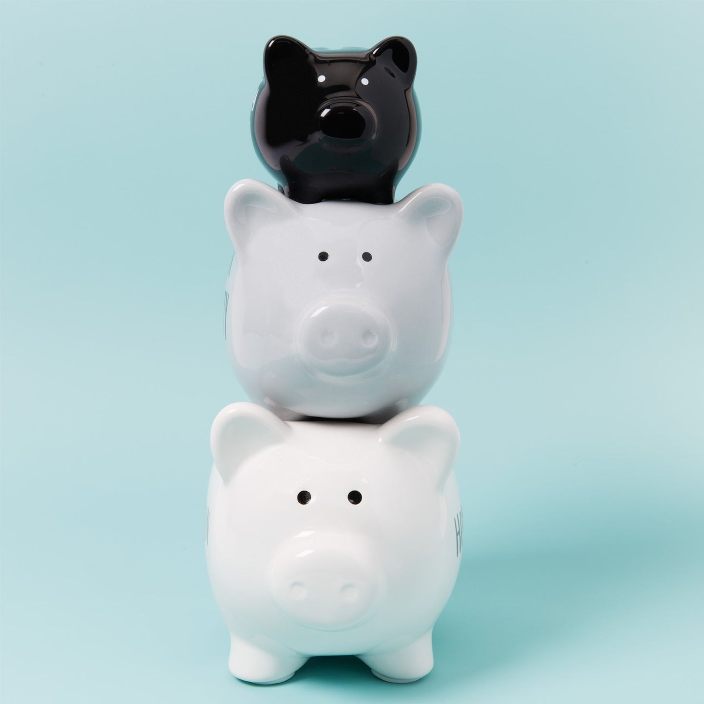 Three piggy banks stacked on top of each other with a light blue background