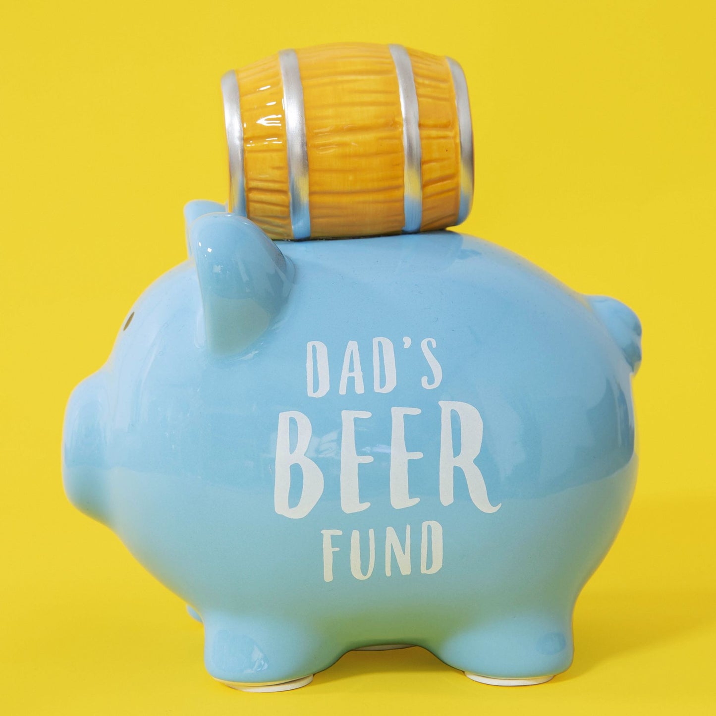 Blue piggy bank with 'Dad's Beer Fund' text and a yellow barrel on a yellow background