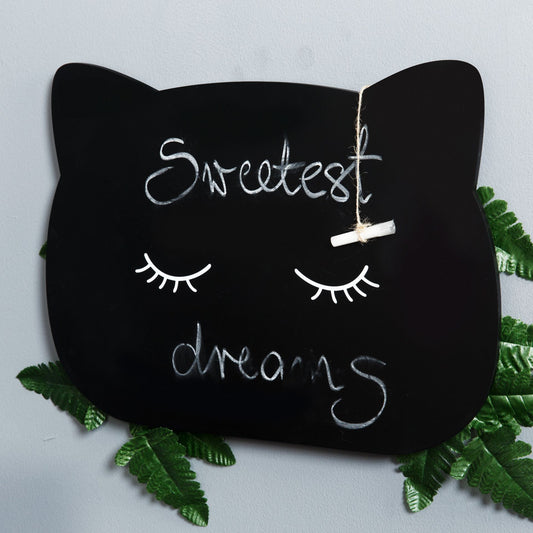 Black cat-shaped pillow with 'Sweetest dreams' text on a light gray background