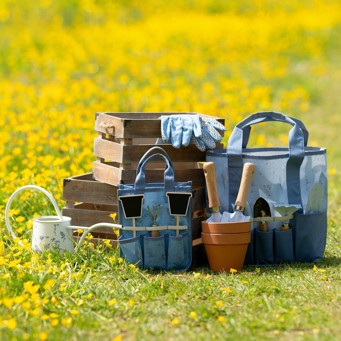 Gardening tools and supplies on a grassy field with yellow flowers