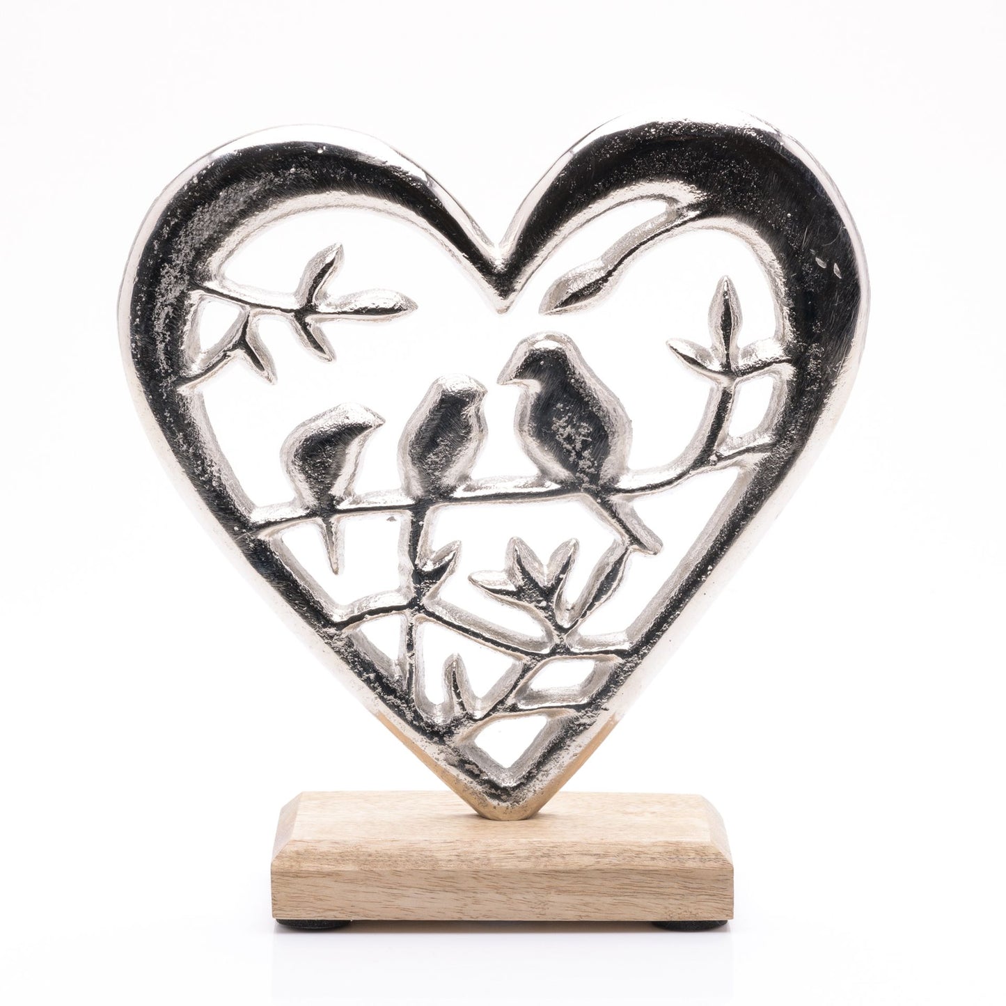 Decorative heart-shaped metal sculpture with birds on a wooden base against a white background