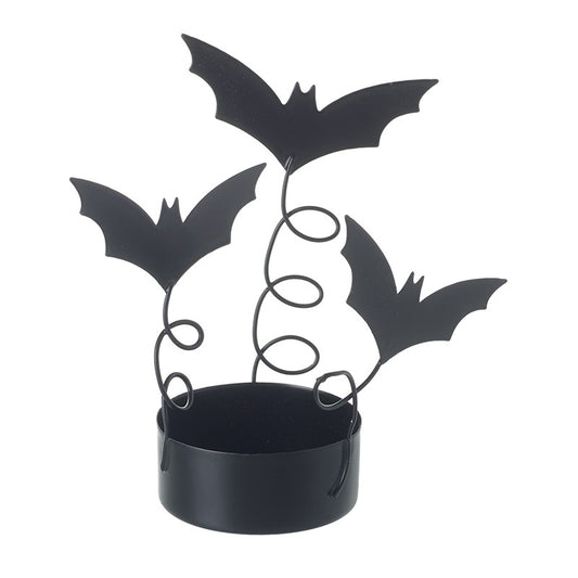 Black decorative holder with bat wings and a candle on a white background