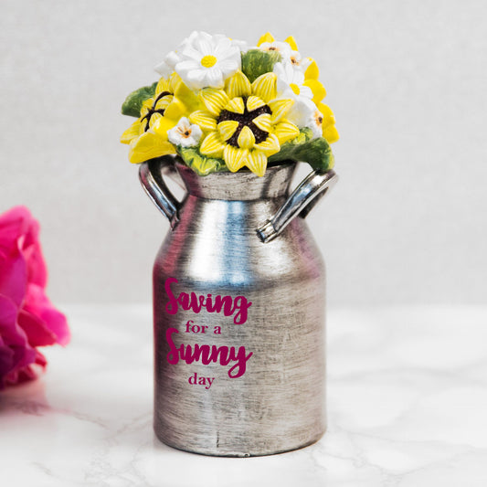 Metallic milk churn with flowers and 'Saving for a Sunny day' text on a light background