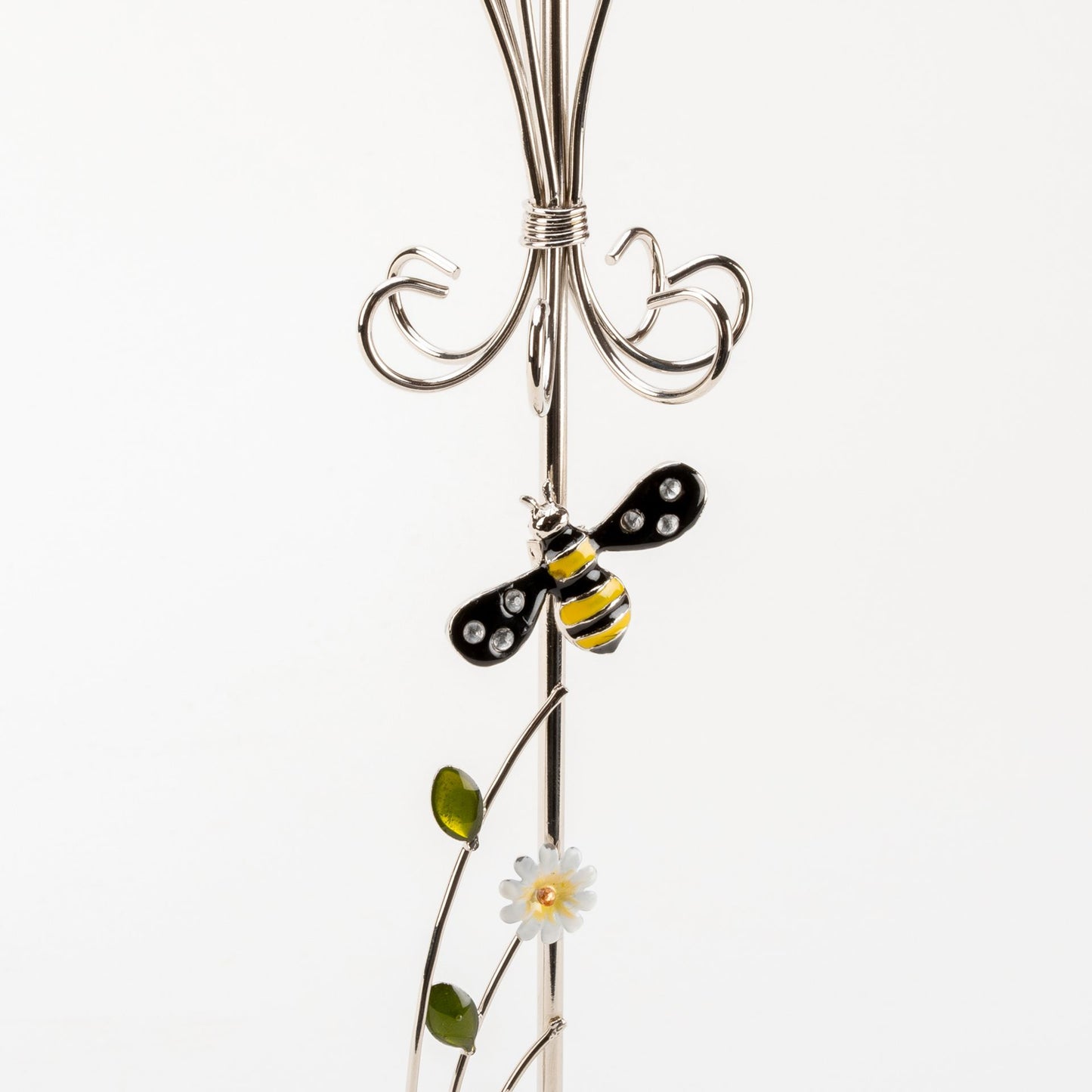 Decorative metal stand with a bee and flower design on a white background