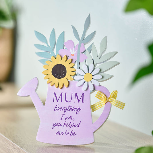 Decorative card shaped like a purple watering can with flowers and text on a light background