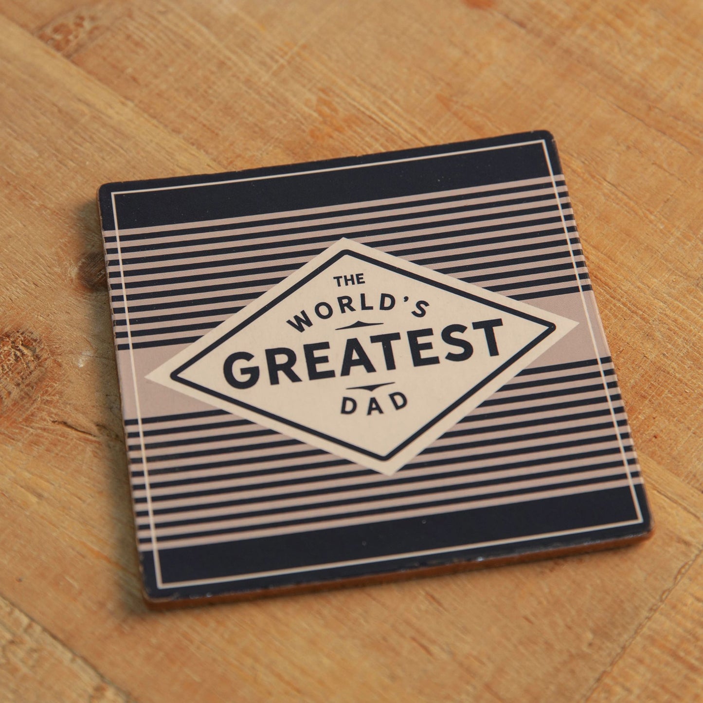 Coaster with 'The World's Greatest Dad' text on a wooden surface