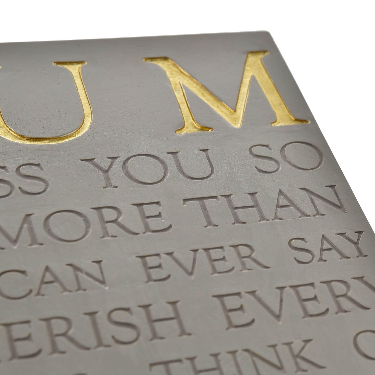 Embossed text on a metallic surface with gold and silver colors.