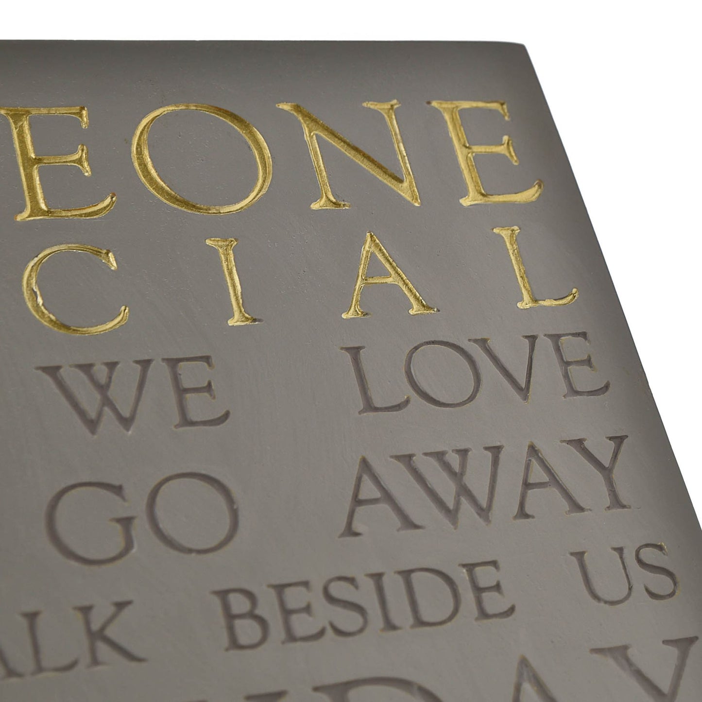 Sheet of paper with embossed text and gold lettering on a gray background