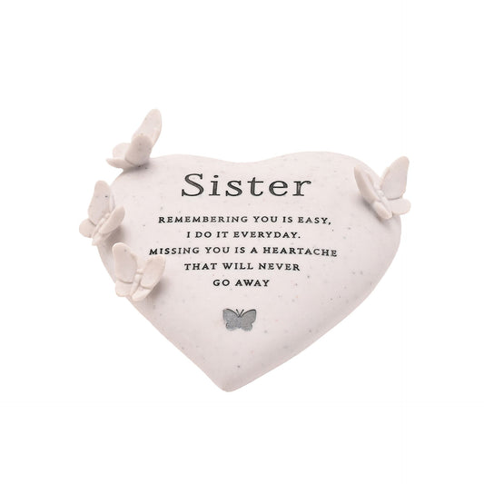 Heart-shaped pillow with butterfly decorations and a sentimental message for sisters on a white background