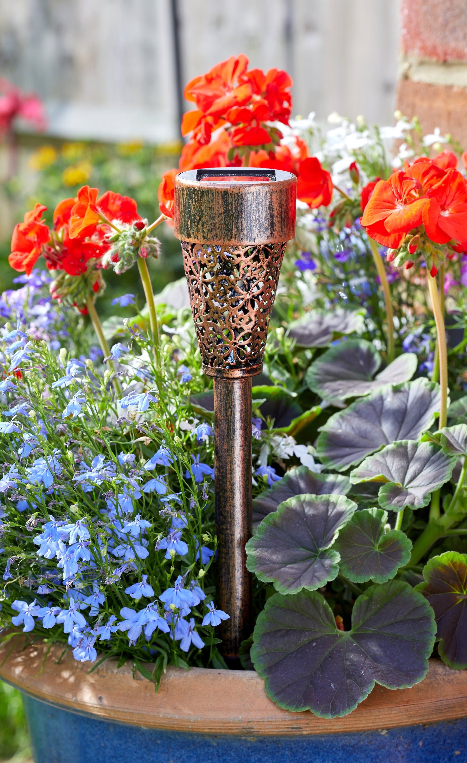 Decorative solar lamp in a garden with flowers and plants