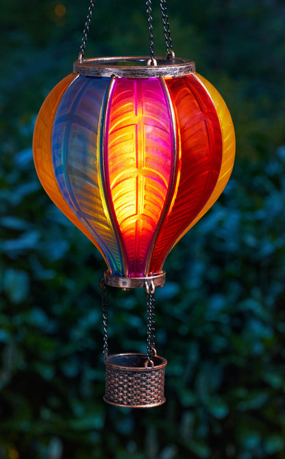 Colorful hanging lantern with a gradient from blue to red against a blurred green background
