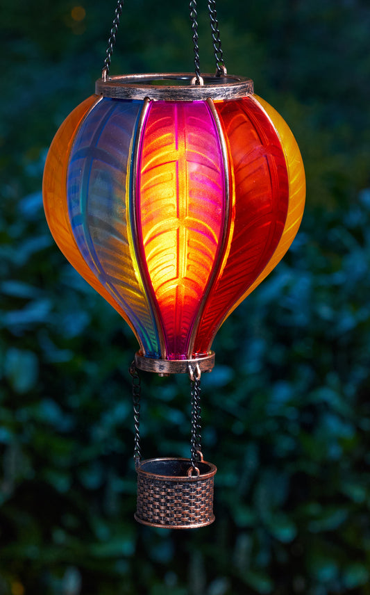Colorful hanging lantern with a gradient from blue to red against a blurred green background