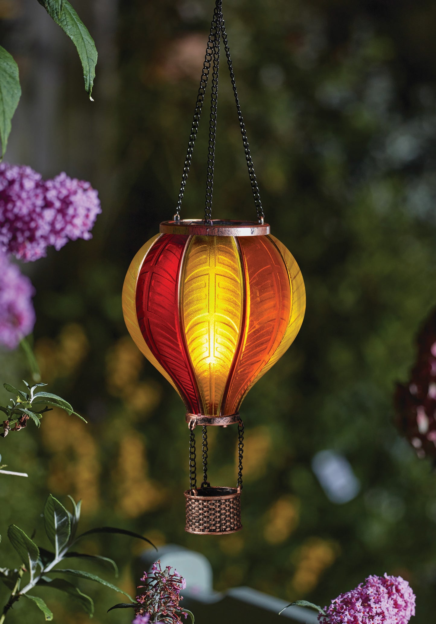 Hanging solar light in the shape of a hot air balloon with a blurred garden background