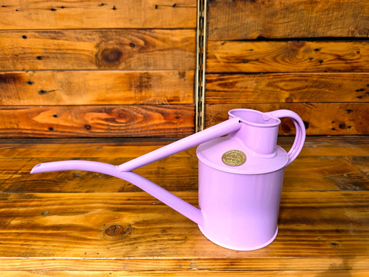 Purple watering can on a wooden surface