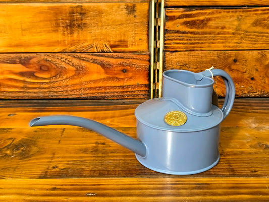 Blue watering can on a wooden background
