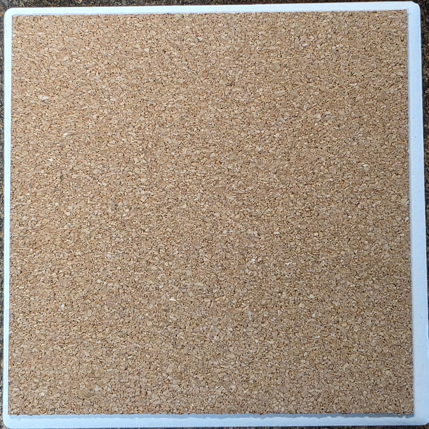 Square tile with a textured beige surface